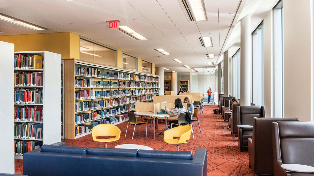 A person sitting at a table in a library.
