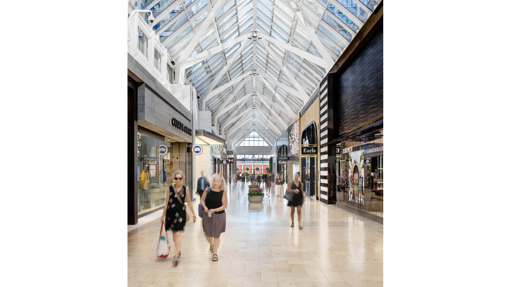 A group of people walking through a shopping mall.
