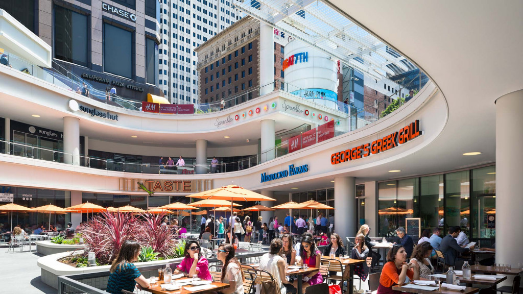 A group of people sitting at tables outside a building.