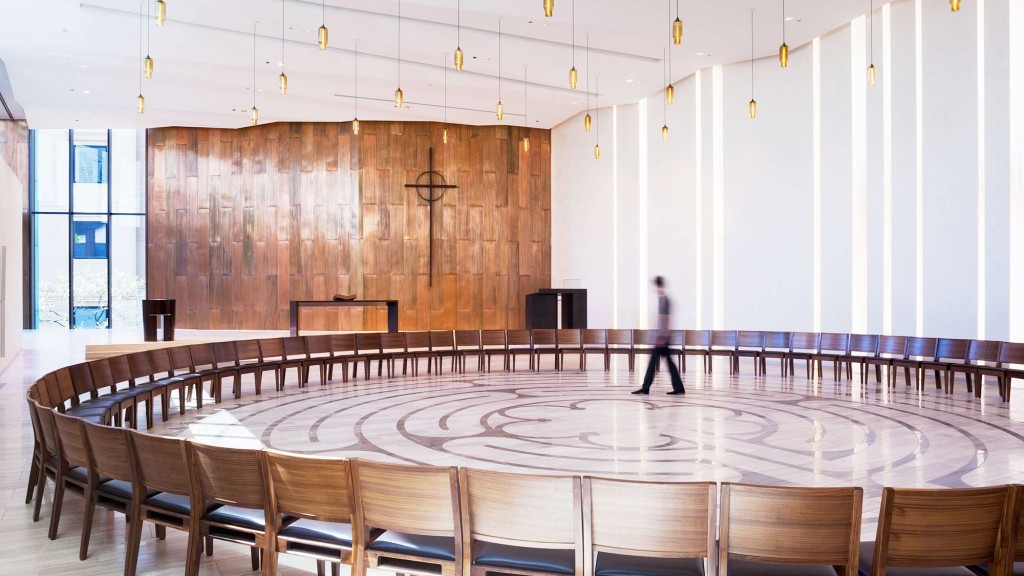 A person standing in a room with chairs and tables.