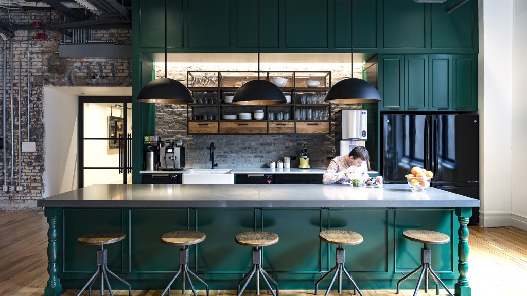 A kitchen with a bar and stools.