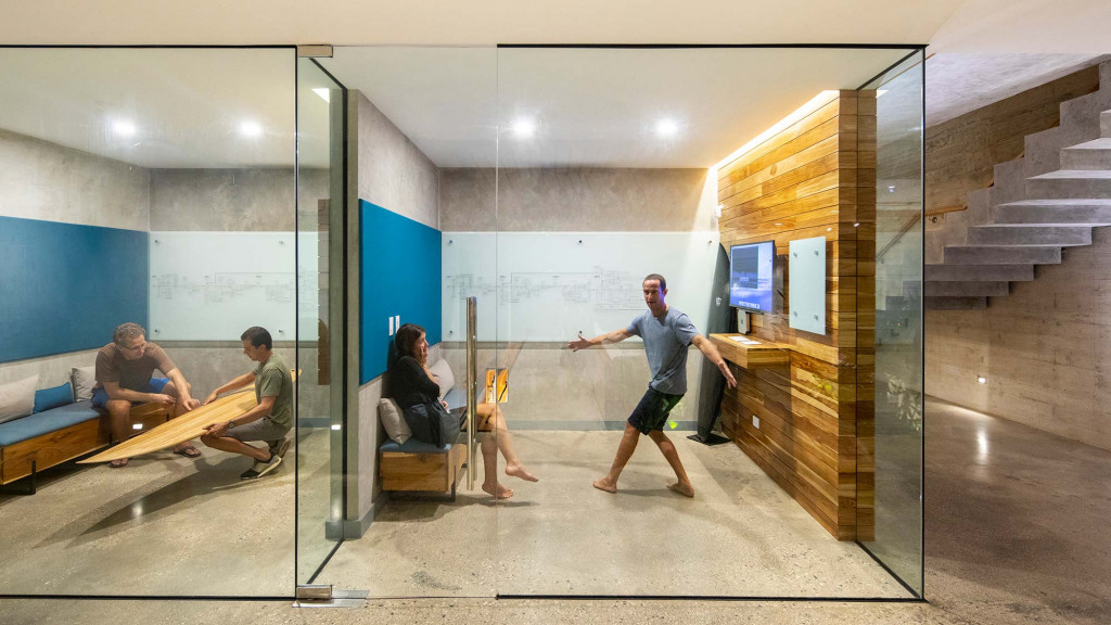 A person standing in a room with people sitting on benches.