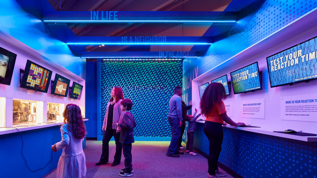 A group of people looking at a display of televisions.