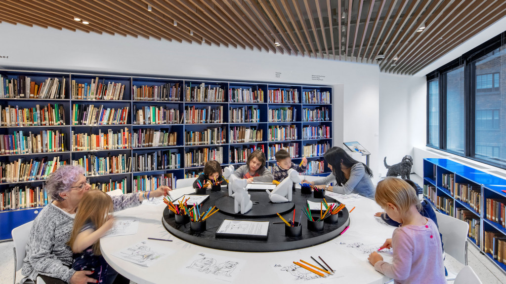 A group of people sitting at a table in a library.