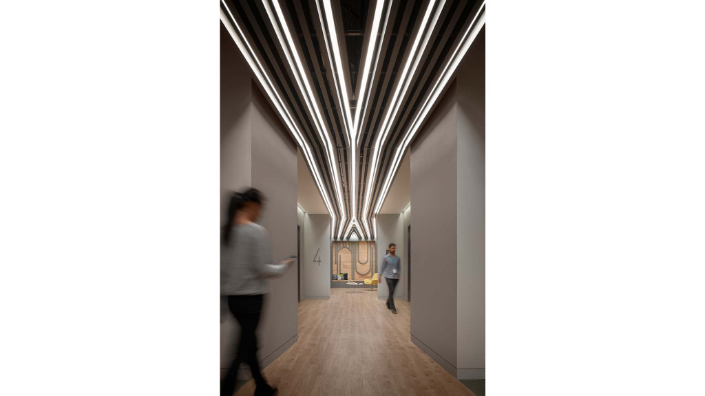 A woman and a man walking through a hallway.