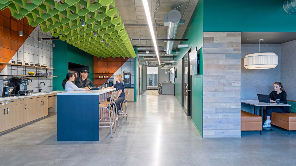 A group of people sitting at a table in a room with green walls.