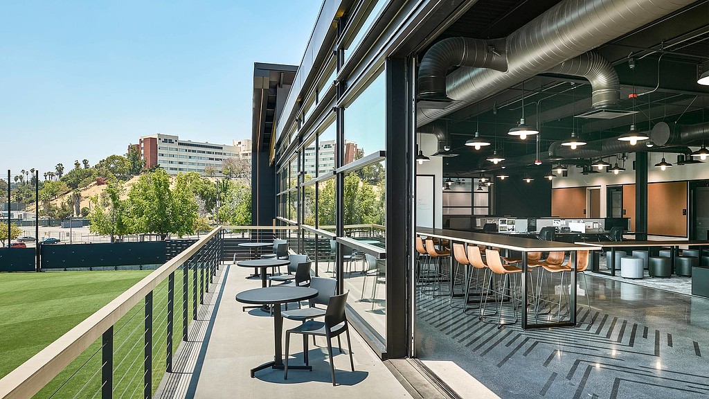 A building with tables and chairs outside.