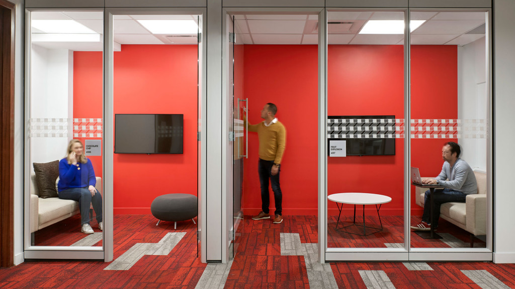 A man and a woman in a room with red walls.