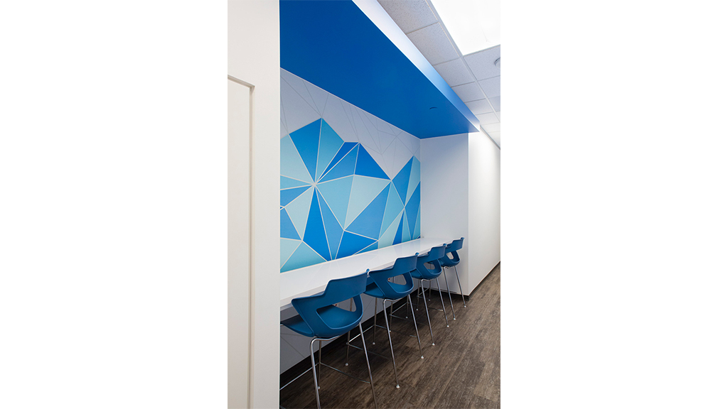 A group of blue chairs in a room with a blue wall.
