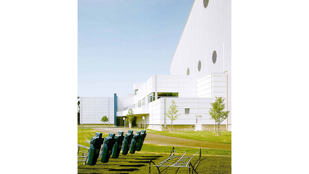 A white building with a bench in front of it.