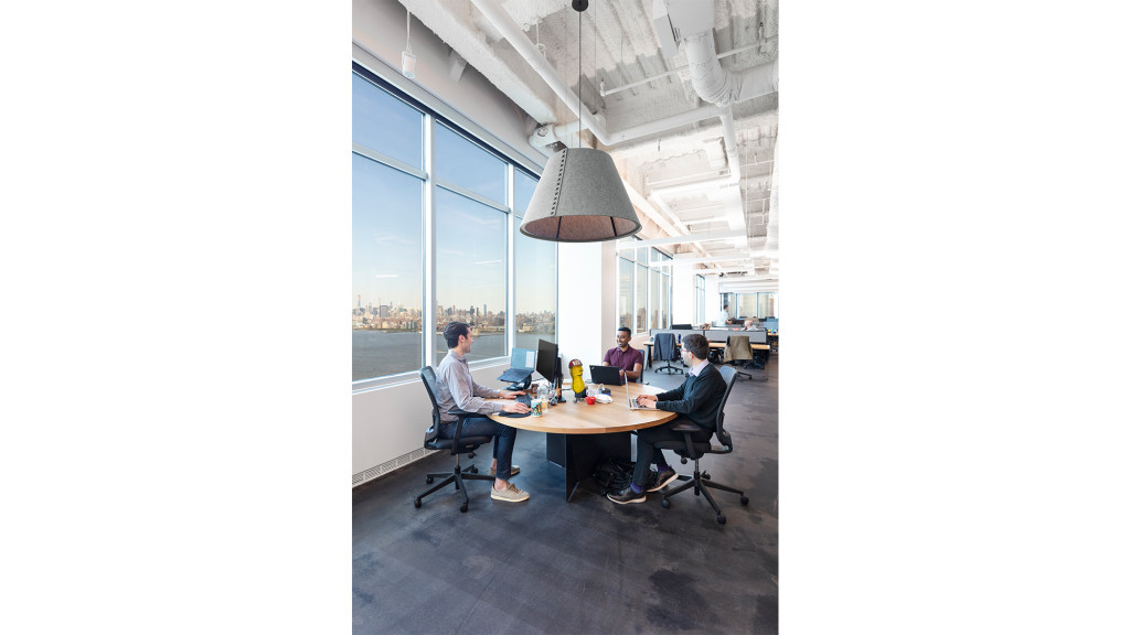 A group of people sitting at a table with computers.