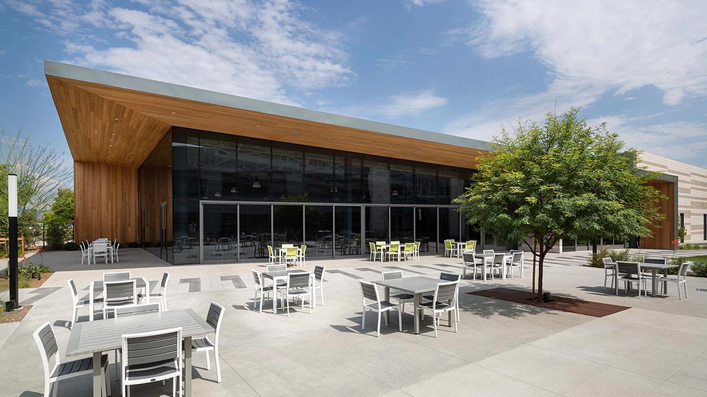 A building with tables and chairs outside.