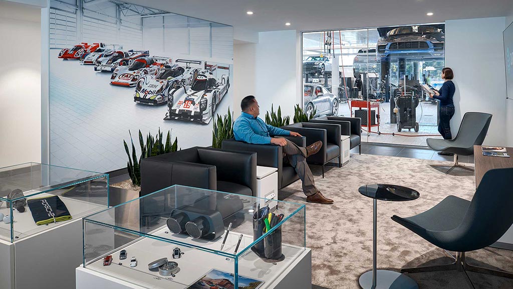 A person sitting on a couch in a room with a glass wall.