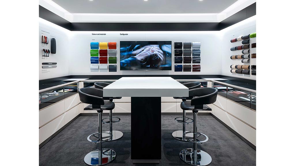 A table with chairs and a tv in the background.