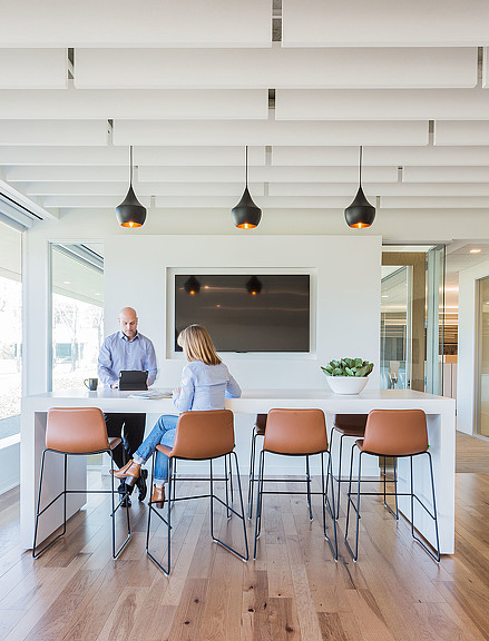A man and a woman sitting at a table with a laptop.