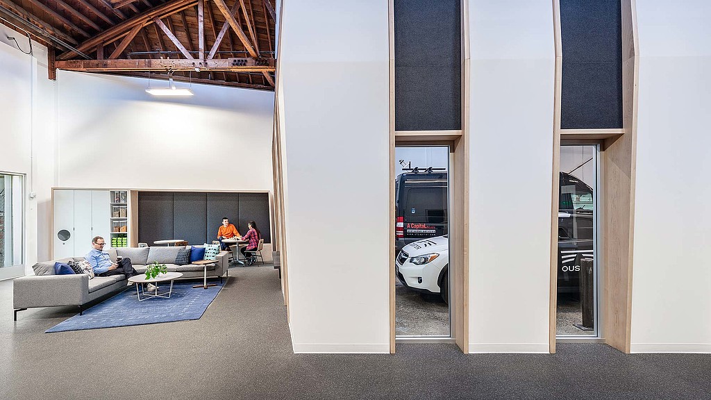 A couple of people sitting on a couch in a room with a car.