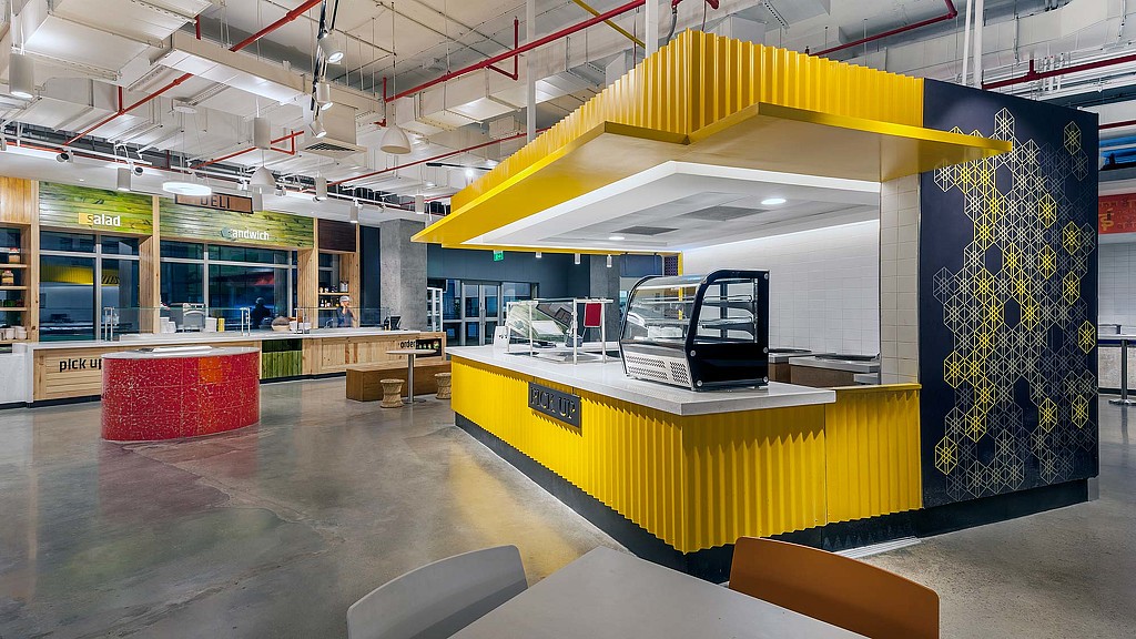 A large room with a yellow and blue wall and a table with chairs.