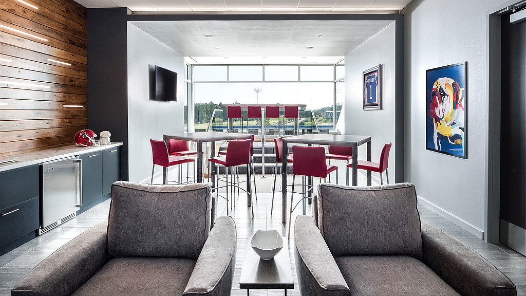 A room with a couch and chairs.