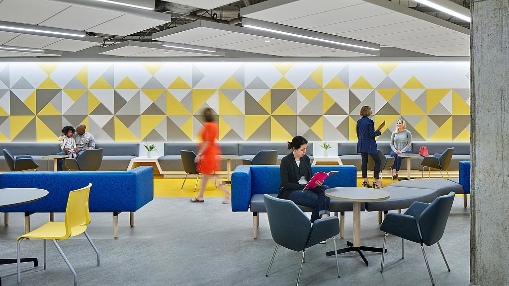 People in a room with tables and chairs.