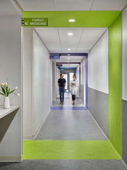 A man and woman walking down a hallway.