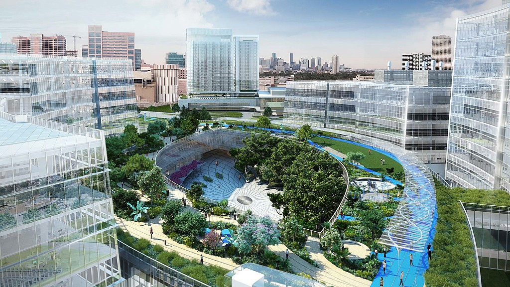 A large courtyard with a fountain and buildings in the background.