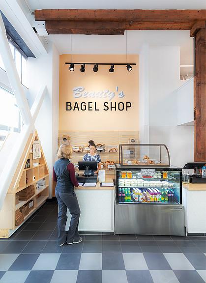 A person standing in front of a counter with a sign on it.