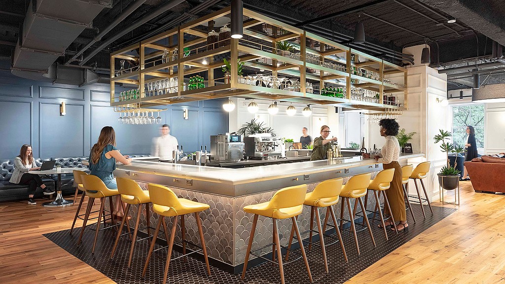 A group of people sitting at a table in a large room.