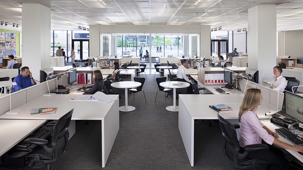 A group of people sitting at desks in an office.