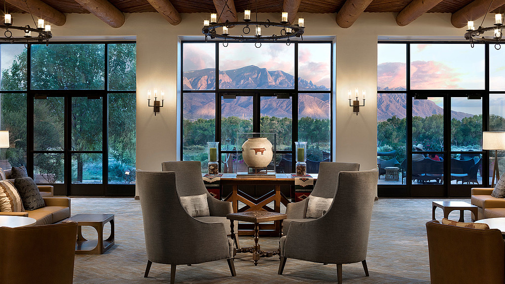 A room with a large window and a table with chairs and a large globe on it.