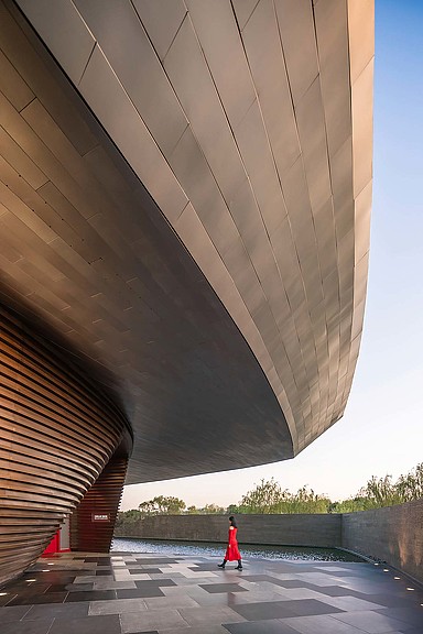 A person walking under a bridge.