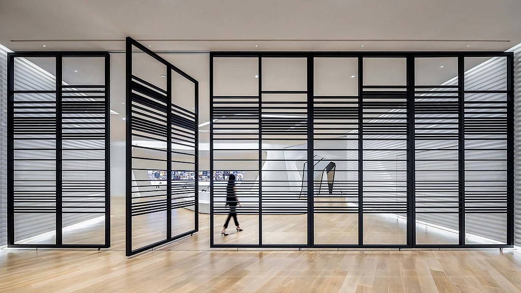 A person walking in a room with a large glass door.