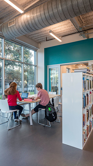 A man and a woman sitting at a table with a laptop.