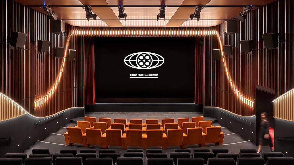 A stage with a screen and chairs.