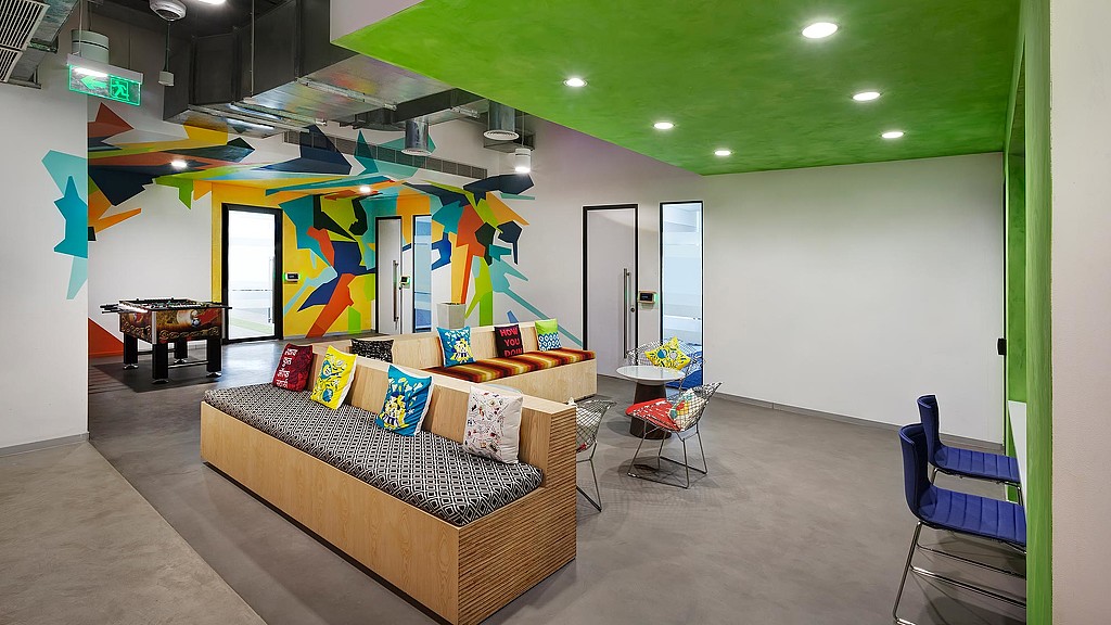 A room with a couch and chairs.