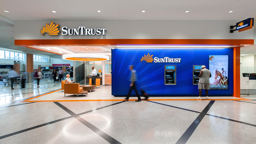 A group of people in a large room with a blue wall.