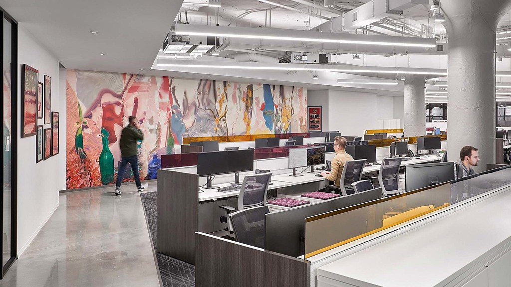 A person standing in front of a counter with computers on it.