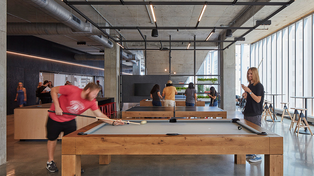 A group of people playing pool.
