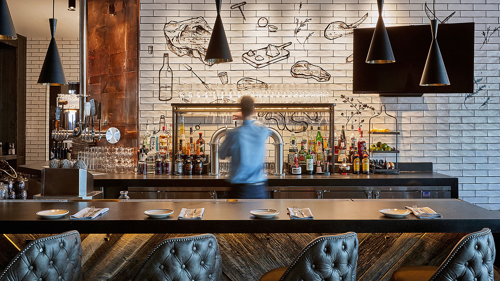 A person standing behind a bar.