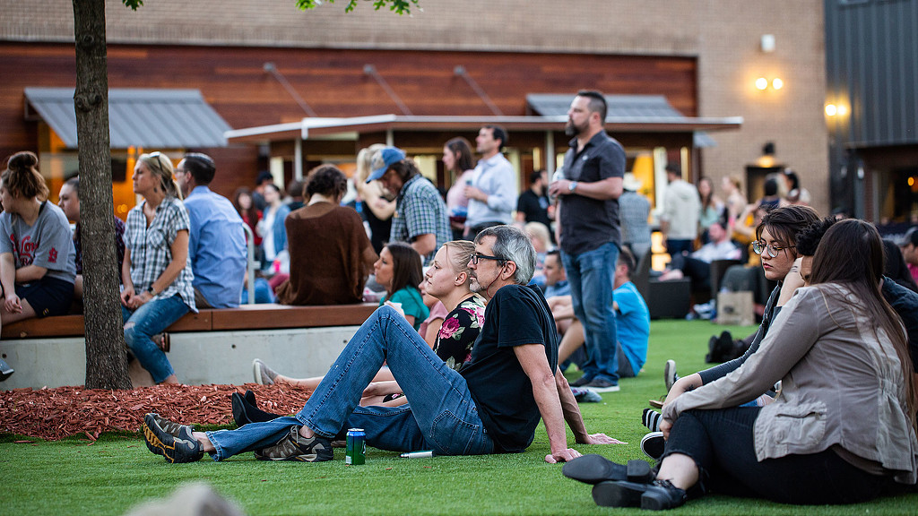 A group of people sitting on the grass.