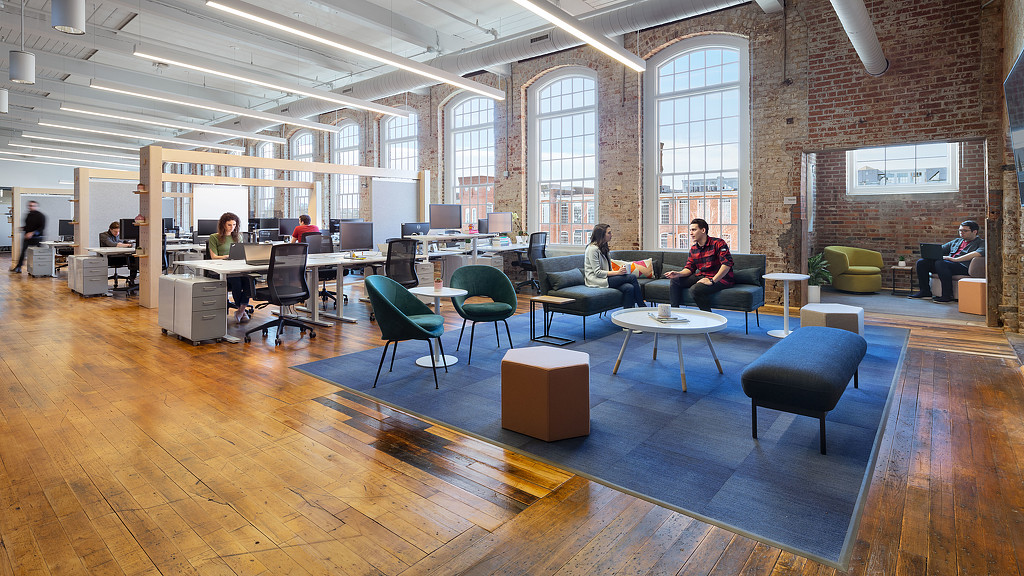 A group of people sitting in a room with a large window.