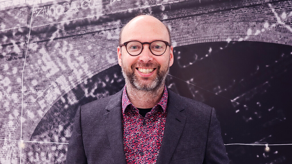 A man wearing glasses and a suit.