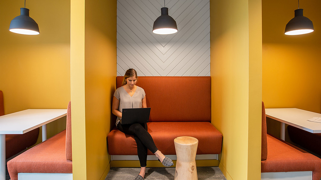 A person sitting on a couch with a laptop.