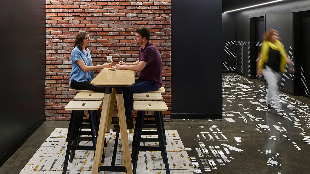 A man and woman sitting at a table with a drink.