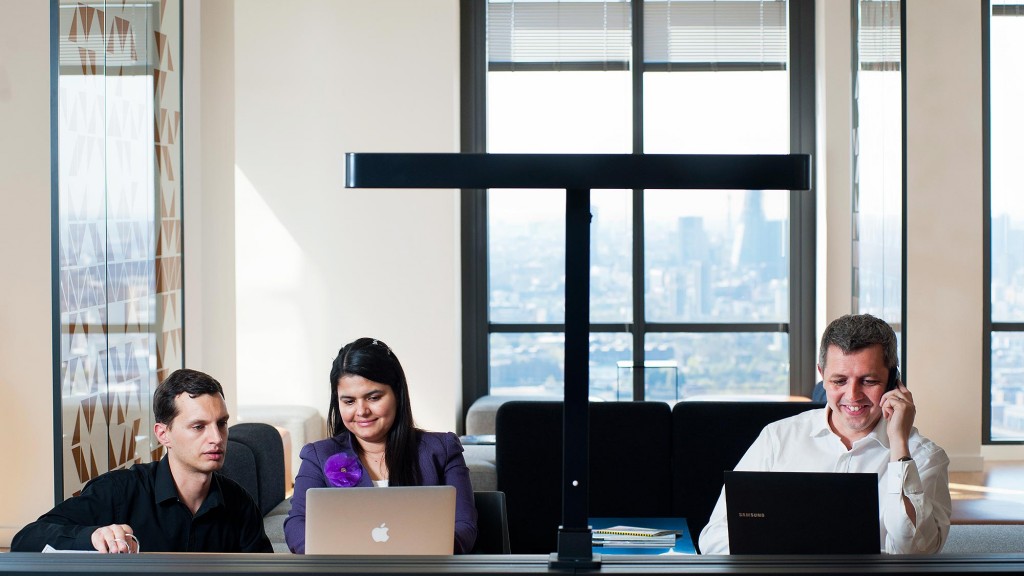 A group of people sitting at a table with laptops.