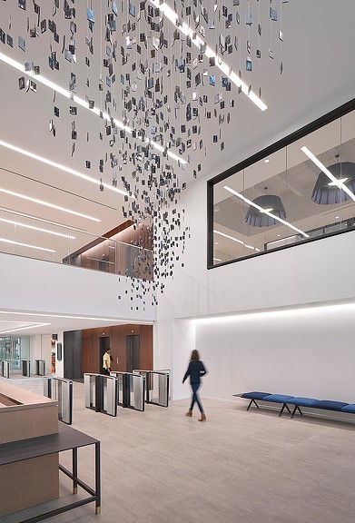 A person walking in a large room with a large ceiling of lights.