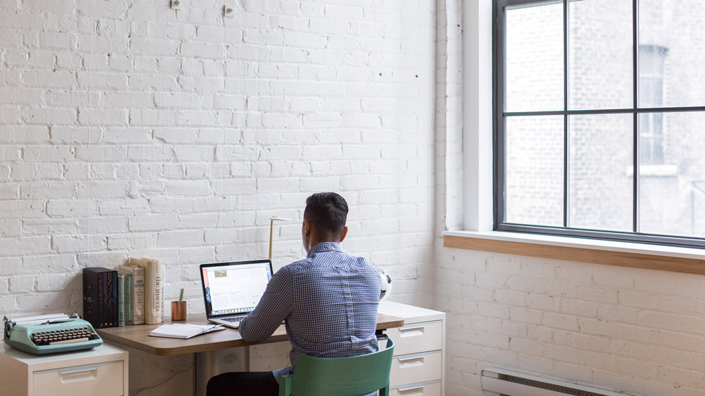 A person sitting at a desk with a laptop.