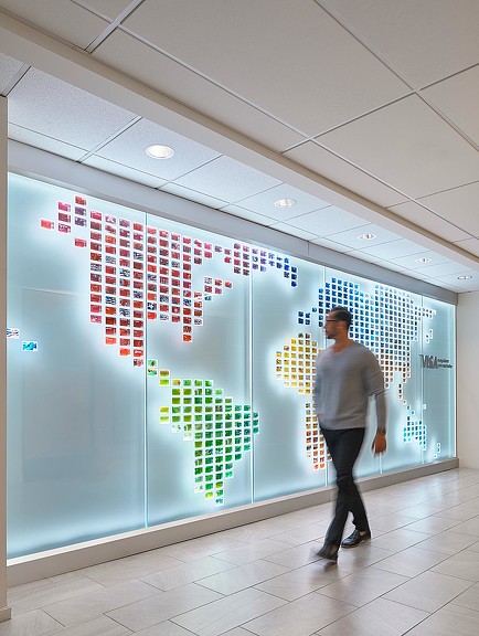 A person standing in front of a large screen with a sign on it.