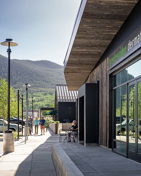 A building with a walkway and people walking by.