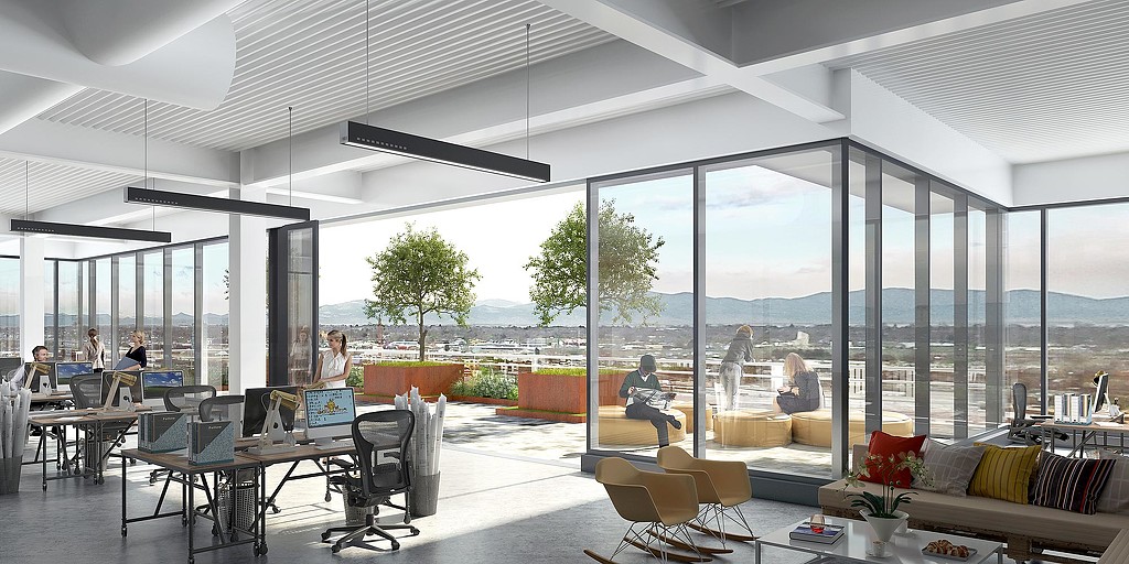 A room with a large window and a group of people sitting at tables.