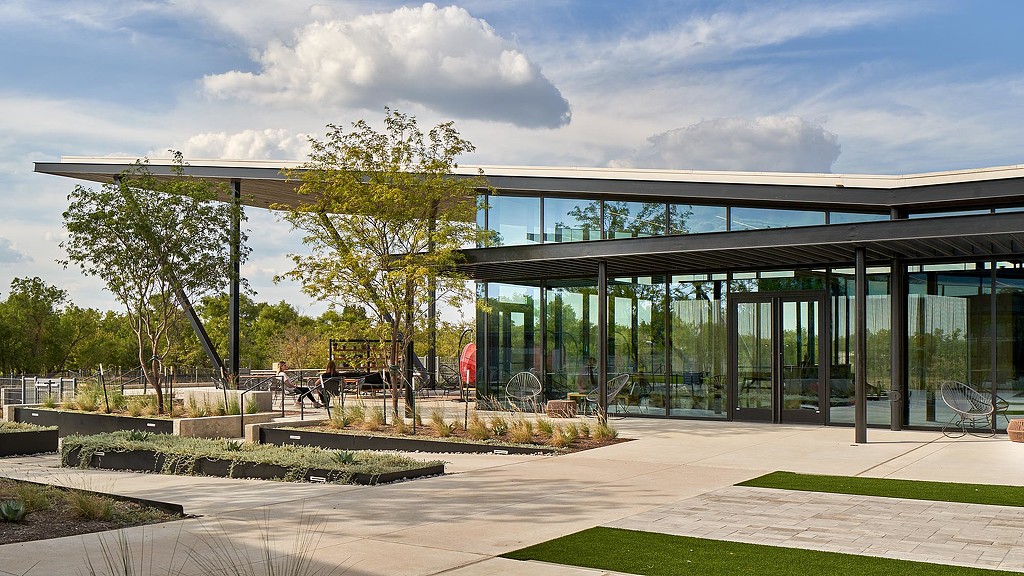 A building with glass walls and trees.